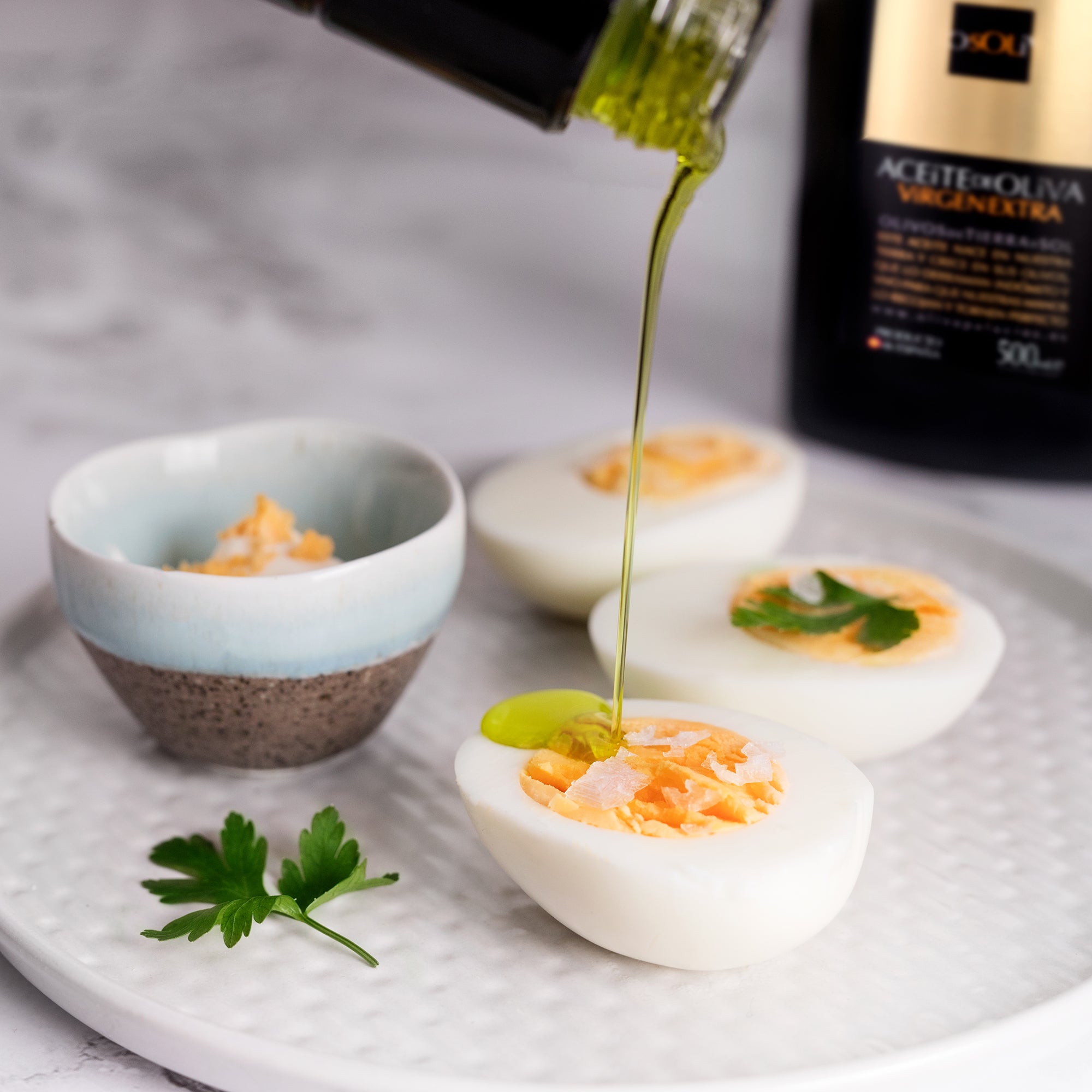 Palacio de los Olivos Picual olive oil poured over halved boiled eggs garnished with parsley.