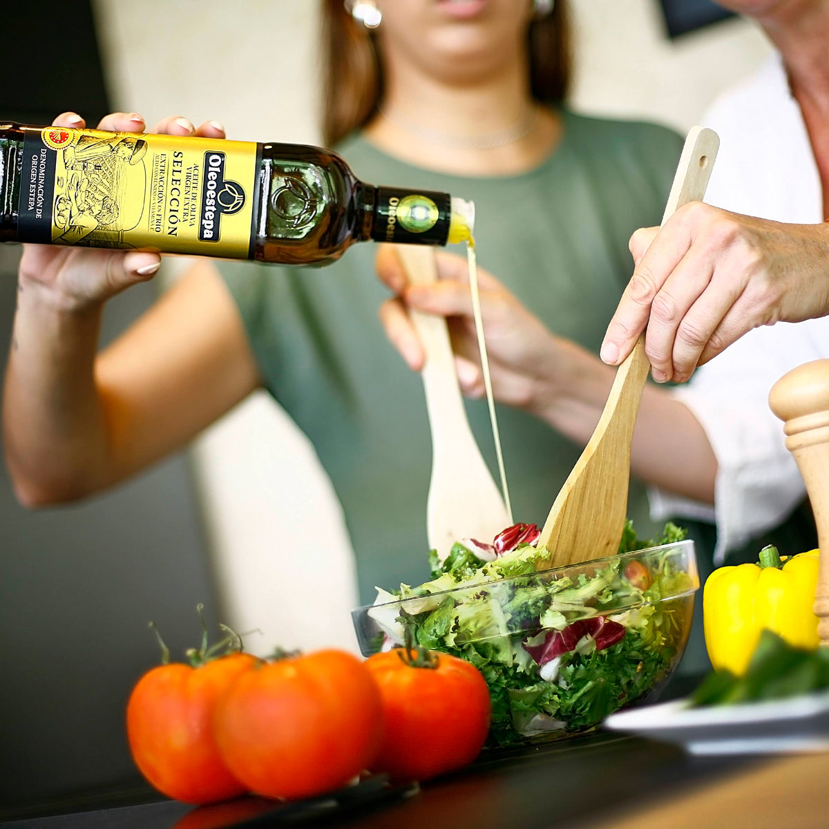 Oleoestepa Selección extra virgin olive oil being poured over a fresh salad.