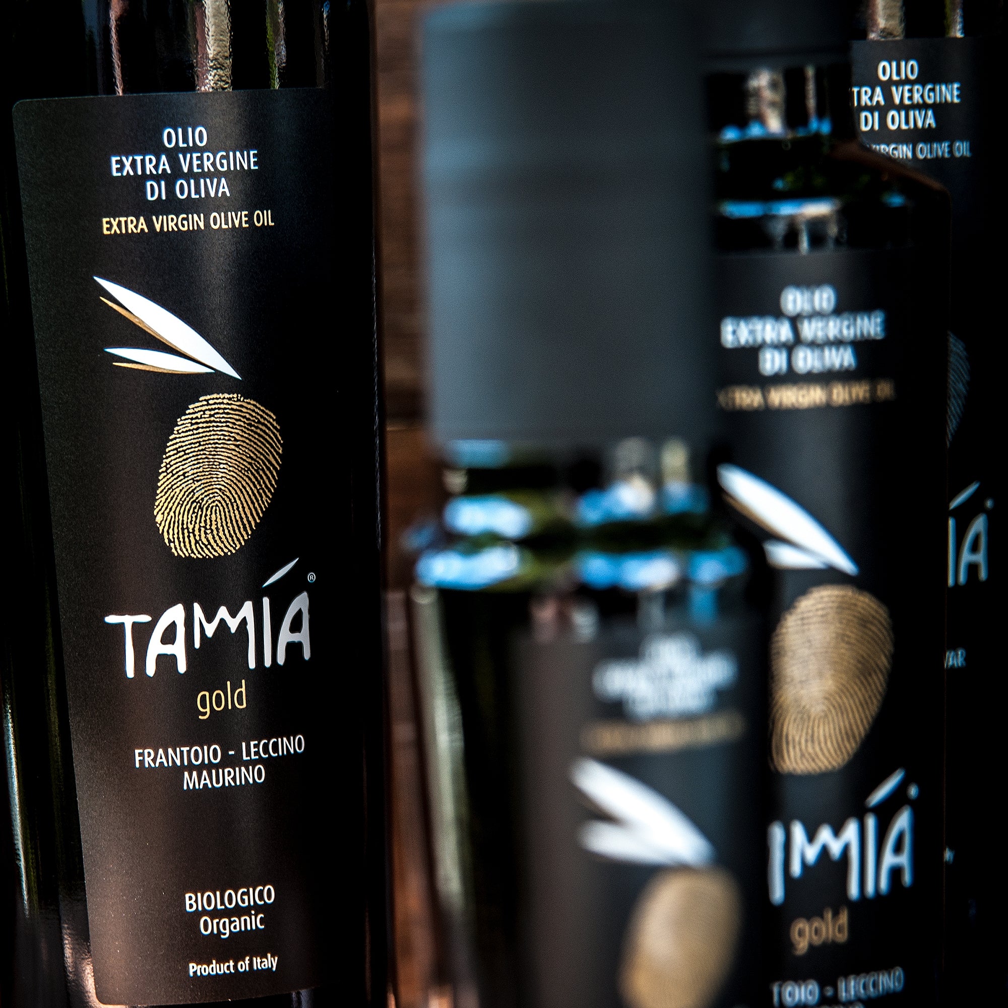 Several Tamia Gold Organic 500 ml olive oil bottles.