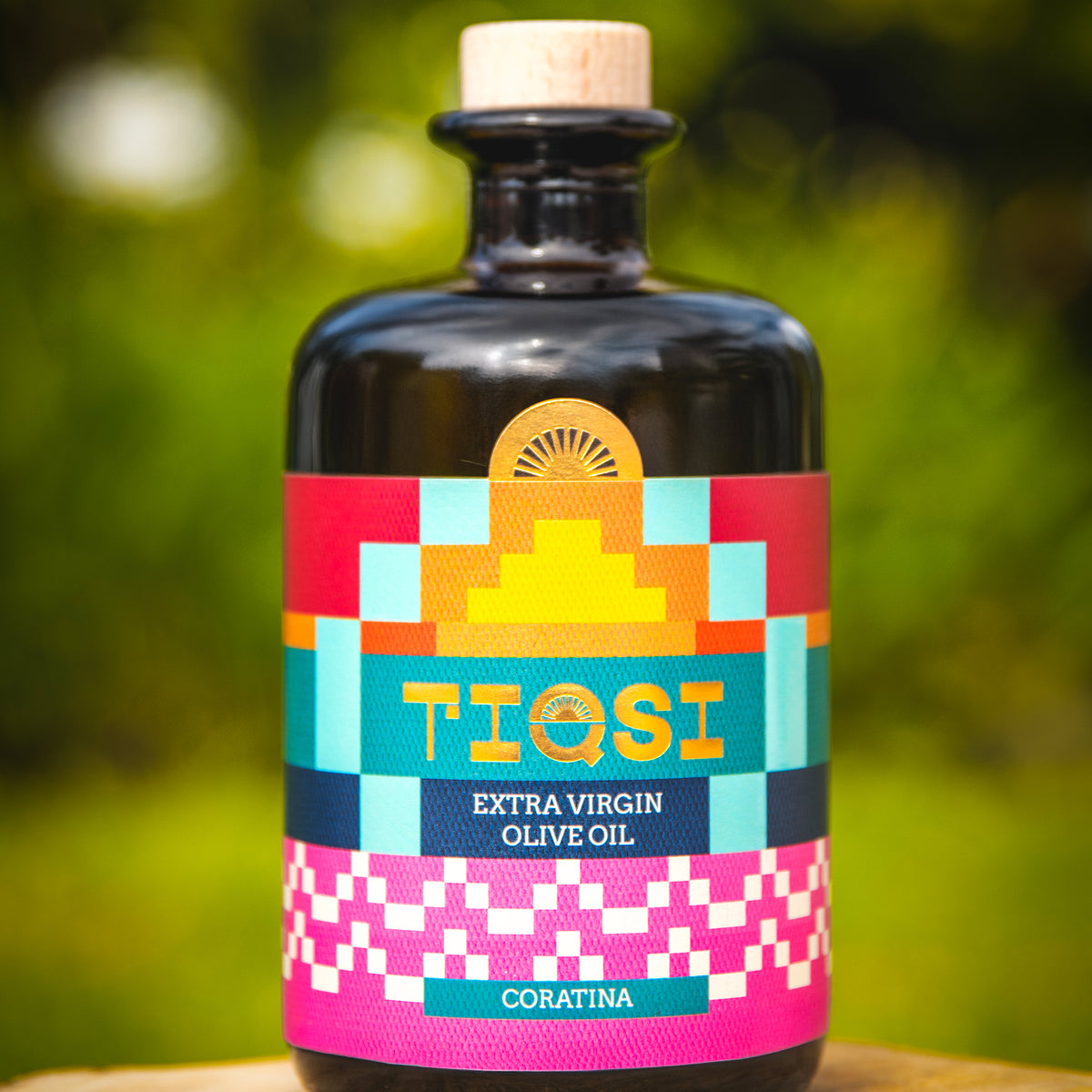 TIQSI Coratina 500 ml Peruvian extra virgin olive oil bottle with colorful geometric label.