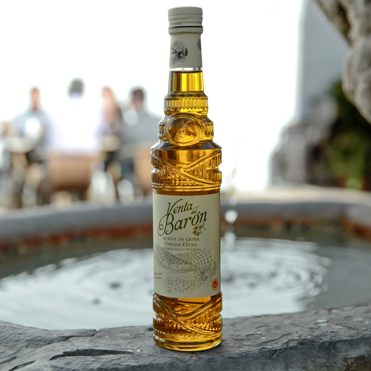 Venta del Barón olive oil bottle beside a fountain in Andalusia, Spain.