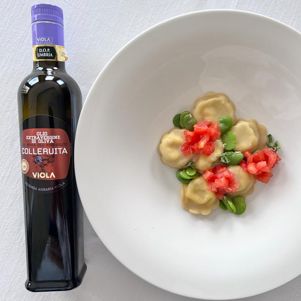 Viola Colleruita DOP Umbria Colli Assisi-Spoleto beside ravioli garnished with beans, tomatoes, and herbs.