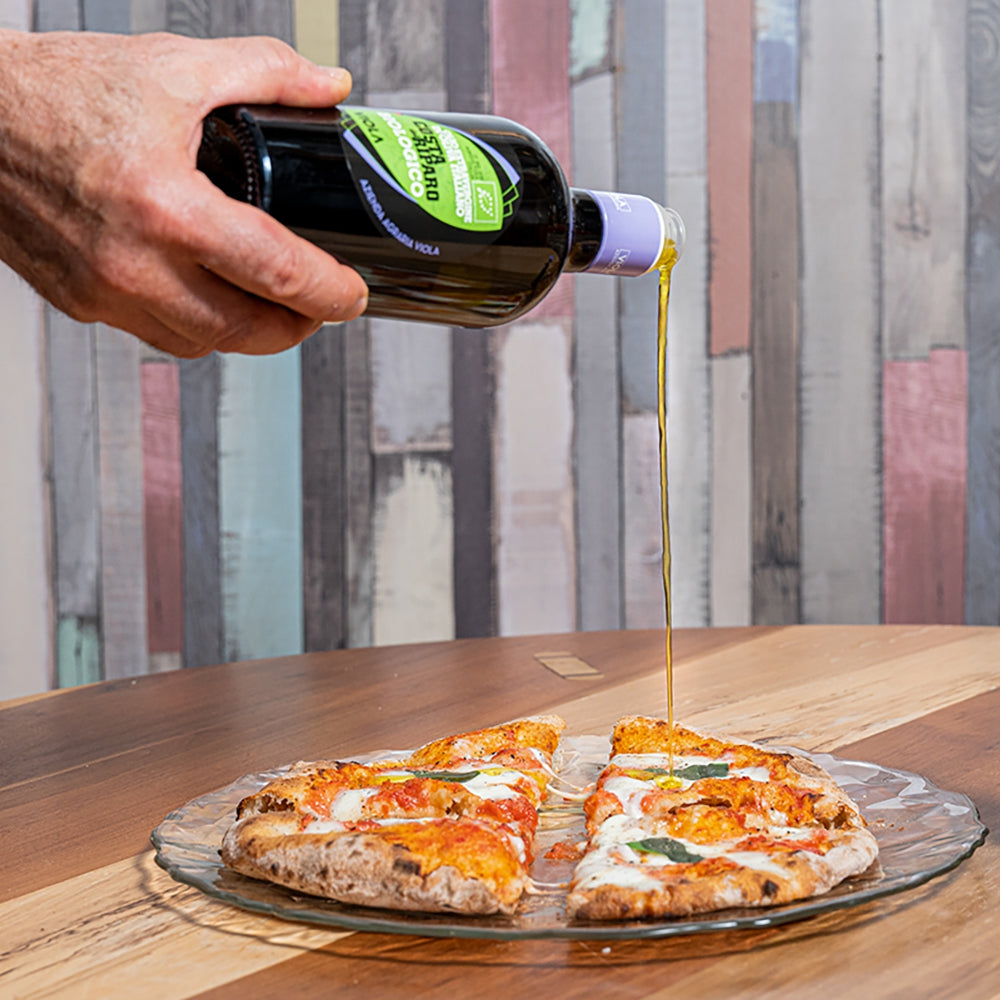 Viola Costa del Riparo Organic olive oil poured over freshly baked pizza.