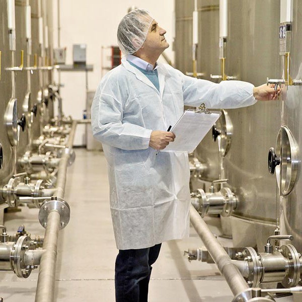 Olive Oil Lovers staff inspecting olive oil storage tanks.