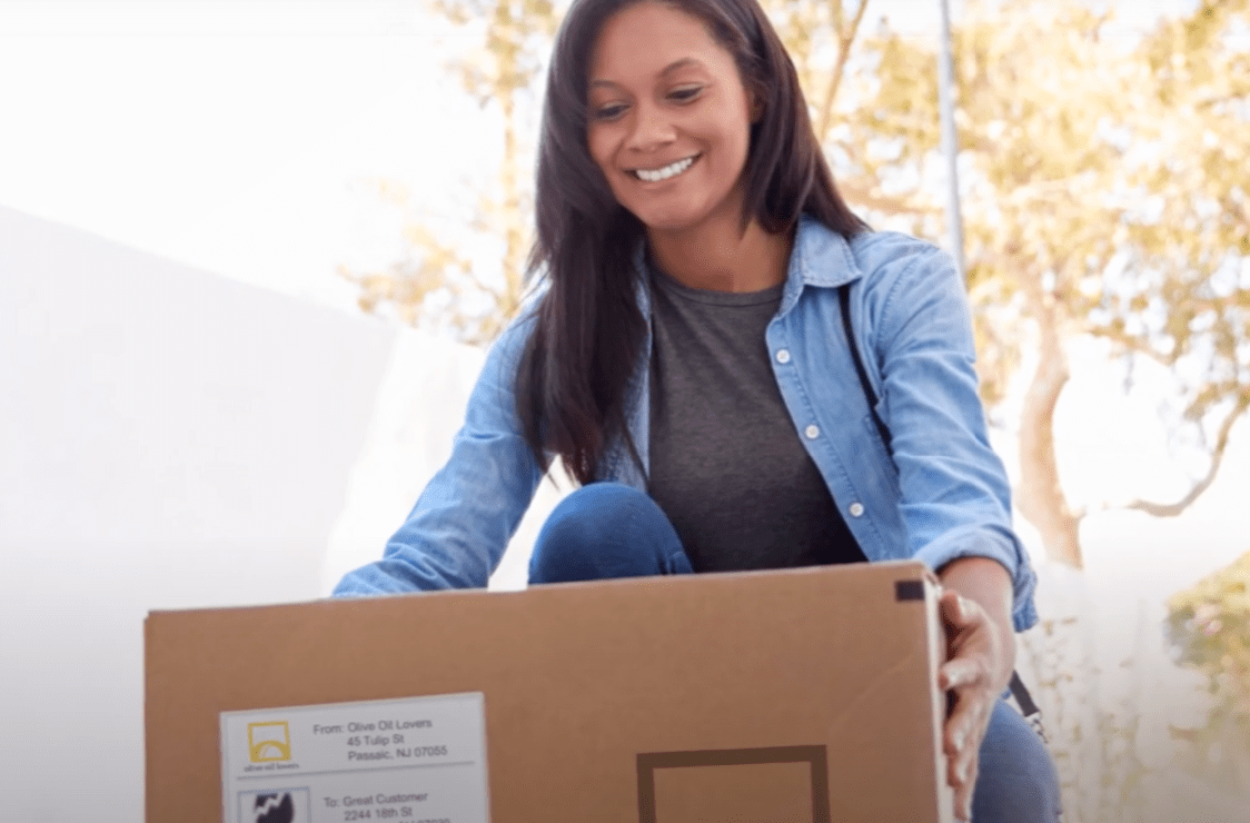 A woman smiling as she picks up her free delivery from Olive Oil Lovers.