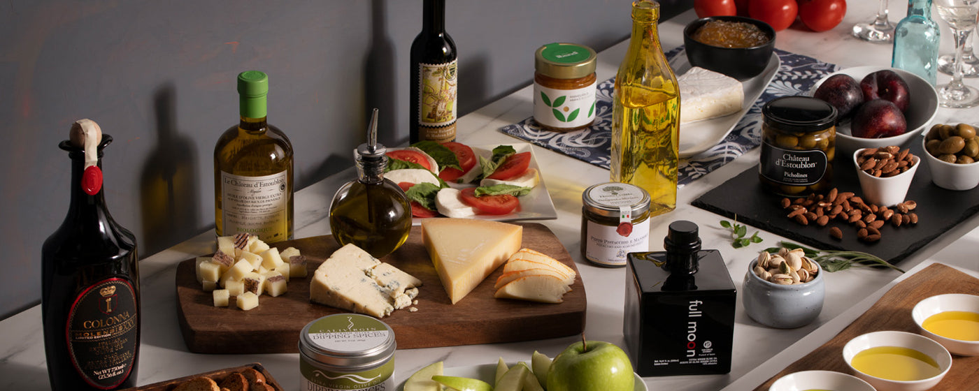 Table featuring various food items and bottles of extra virgin olive oil offered by Olive Oil Lovers.