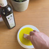 Dipping a small piece of bread into Oro Bailen Picual Novello extra virgin olive oil.